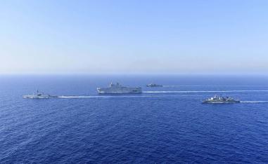 French Tonnerre helicopter carrier, center, and French Lafayette frigate, left, are escorted by Greek and French military vessels 