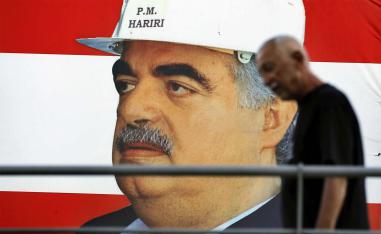 A man passes a poster of slain Lebanese Prime Minister Rafik Hariri in Beirut
