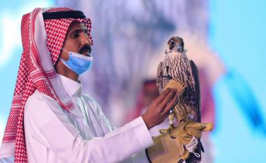 سعودي يحمل الصقر الذي تم بيعه بـ170 ألف دولار