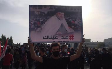 متظاهر عراقي يرفع راية تأييد لمقتدى الصدر