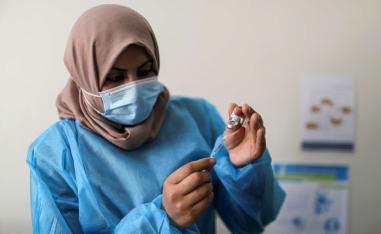 ممرضة تحضر حقنة من لقاح كورونا في غزة