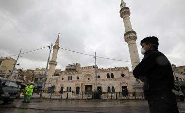 شرطي أردني يقف في حراسة أمام مسجد الحسيني في وسط عمان