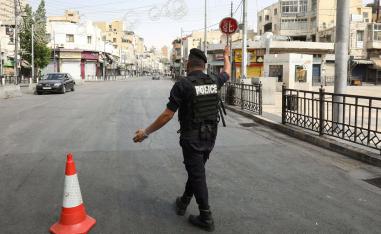 شرطي أردني يحرس نقطة تفتيش خلال حظر التجول في المملكة