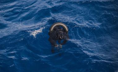 A dead migrant floats on the sea after his boat capsized off Libyan coast
