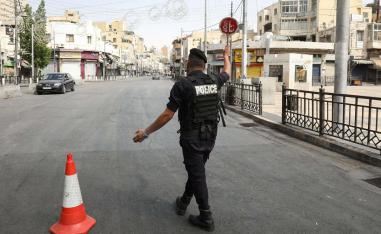 شرطي اردني يحرس نقطة تفتيش خلال حظر تجول في المملكة