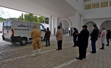 أقارب يصلون بالقرب من سيارة تحمل جثة ضحية كوفيد -19 في تونس 