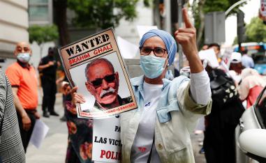 People hold placards as they protest against Brahim Ghali outside the High Court