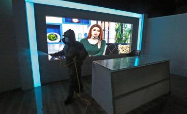 موظف صحي يرش مطهرات في محطة تلفزيون
