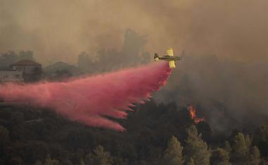 A plane sprays wildfires burning for for the second day near Shoresh, on the outskirts of Jerusalem