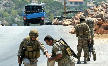 Lebanese soldiers stand next to a a truck carrying a multiple rocket launcher after confiscating it