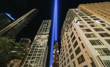 The annual Tribute in Light projects two pillars of light into the night sky next to the buildings overlooking the 9/11 Memorial & Museum in New York City