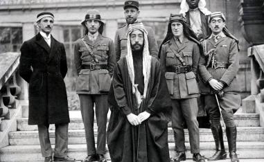 الملك فيصل ويظهر خلفه الأول من اليمين تحسين قدري وتوماس إدوارد لورنس ثم نوري السعيد ورستم حيدر