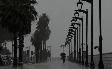 لبناني يمشي على كورنيش بيروت برغم الامطار الشديدة
