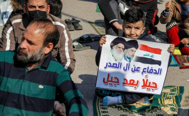 طفل عراقي يرفع لافتة تأييد لمقتدى الصدر