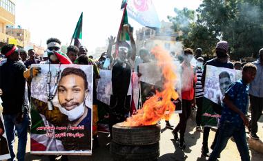 Sudanese demonstrators carry posters of killed protesters as they protest in Khartoum 