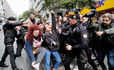 Police officers scuffle with a group of protesters in Istanbul