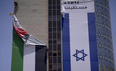 عمال إسرائيليون يزيلون علما فلسطينيا من مبنى في بلدة رامات غان