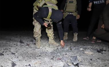 Fighters affiliated with the Hayat Tahrir al-Sham jihadist group in Syria inspect the site of a reported drone attack 