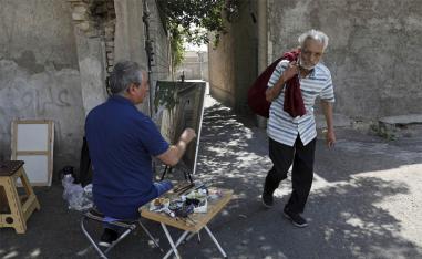 Painter Hassan Naderali paints an old building in the historic neighborhood of Oudlajan, in Tehran