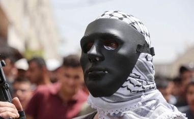 فلسطيني يرتدي قناعا في تشييع قتلى هجوم إسرائيلي في الضفة الغربية
