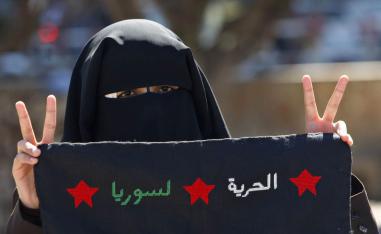 فلسطينية من حركة حماس في غزة ترفع شعارا مؤيدا للثورة على نظام الأسد