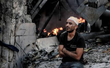 فلسطيني جريح جنب بيته المدمر في غزة بعد قصف إسرائيلي