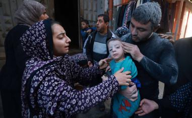 عائلة فلسطينية تخرج ابنها من دار دمرها القصف الإسرائيلي في غزة