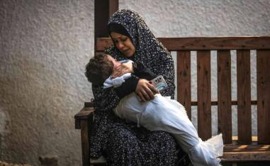 فلسطينية من عائلة عاشور تحتضن ابنها الذي قتل في قصف إسرائيلي لرفح