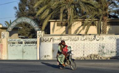 A motorcyclist rides past a high school at Panjgur district in Balochistan province 
