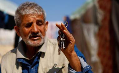 فلسطيني يعرض مفاتيح بيته المدمر في غزة
