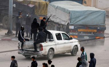 مسلحون فلسطينيون يراقبون إيصال المساعدات الإنسانية