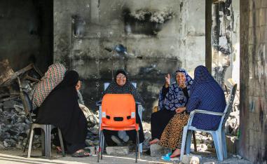 فلسطينيات في مبنى مدمر من القصف في غزة