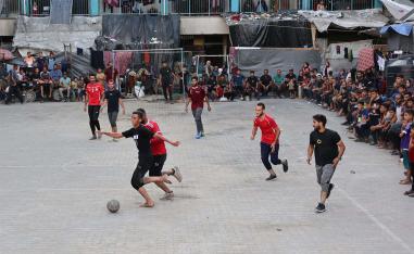 Playing football in the courtyard of a school-turned-shelter