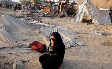 A Palestinian woman cries at the site following Israeli strikes on the tent camp sheltering displaced people