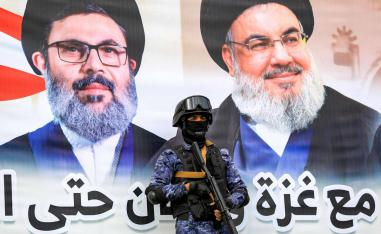 مقاتل حوثي أمام جدارية لحسن نصرالله وهاشم صفي الدين في صنعاء