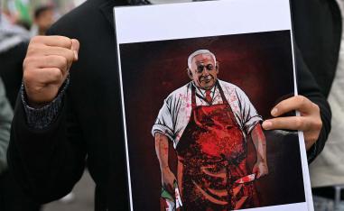 A demonstrator holds a placard depicting Israeli PM  during a Pro-Palestinian rally in Warsaw