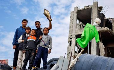 لاعب المنتخب الفلسطيني أحمد اللولحي يستخلص كأس بطولة سابقة من منزله المدمر
