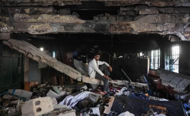 A man sits amid the debris at the Fahmi Al-Jarjawi School in Gaza City on May 26