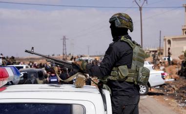 A member of Internal Security Forces holds a gun at an Internal Security Forces checkpoint in Syria