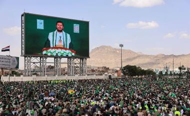 Abdul-Malik al-Houthi appears on a screen as people, mainly Houthi supporters, gather to mark the Prophet Muhammads birthday, at Sabeen Square in central Sanaa