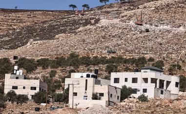 Israeli settlers use bulldozers to pave a road for a new settlement on the outskirts of the occupied West Bank village of Al-Mughayyir, north of Ramallah