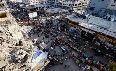 People gather and shop at a local market, in Nuseirat, central Gaza Strip