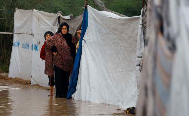Displaced Palestinians shelter in a flooded tent camp on a rainy day in Nuseirat, central Gaza Strip, December 12, 2025.