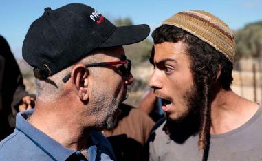 An Israeli settler argues with a Palestinian farmer, during olive harvesting in Silwad, in the Israeli-occupied West Bank, October 29, 2025. 