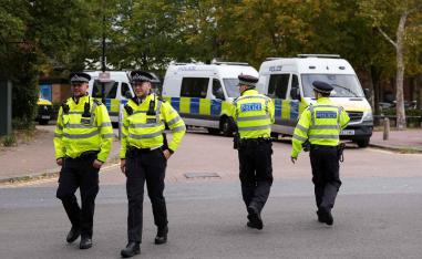 Police officers walk outside a court building in London.