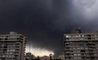 Smoke rises after a reported strike on fuel tanks at an oil refinery in Tehran