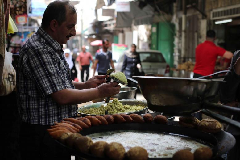 More than what’s on a plate. A Palestinian man makes falafel, a traditional dish consisting of fried chickpeas, on a street in Nablus
