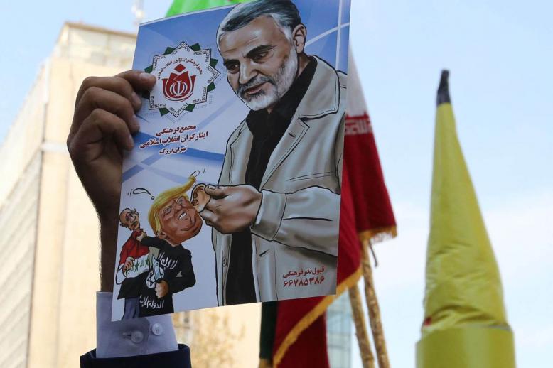 متظاهر يرفع صورة لقاسم سليماني قائد فيلق القدس الإيراني المسؤول عن الميليشيات الشيعية في المنطقة