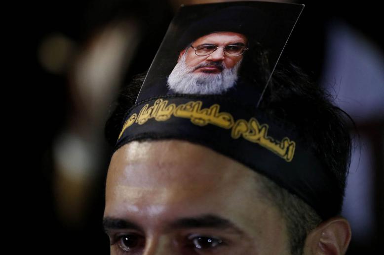 ناشط من حزب الله يرفع صورة لحسن نصرالله على رأسه