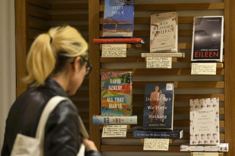 امرأة تنظر إلى قائمة الكتب القصيرة لجائزة مان بوكر في أحد متاجر الكتب بلندن